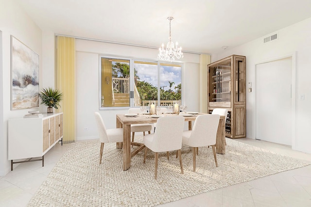 dining room with light tile patterned floors and an inviting chandelier