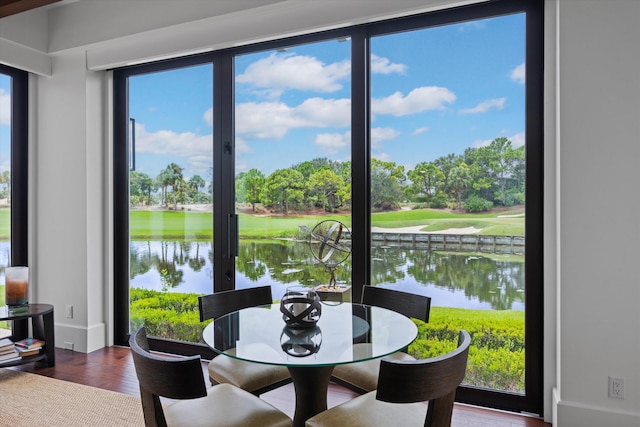 dining area featuring wood-type flooring and a water view