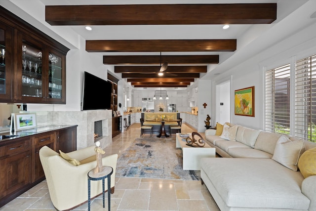 living room featuring beamed ceiling and a high end fireplace