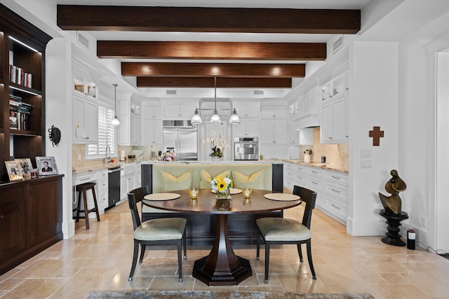 dining room featuring sink and beam ceiling