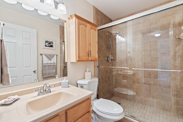 bathroom featuring an enclosed shower, vanity, and toilet