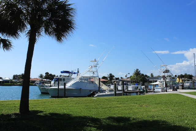 view of dock with a water view and a yard