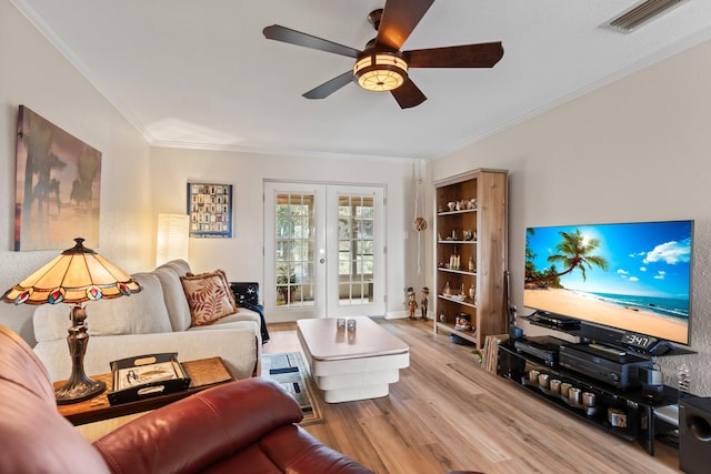 living room with ornamental molding, ceiling fan, french doors, and light hardwood / wood-style flooring