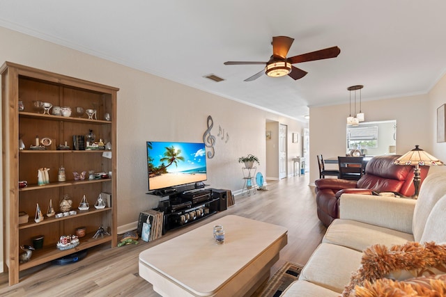 living room with ceiling fan, light hardwood / wood-style flooring, and crown molding