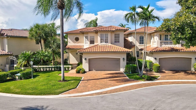 mediterranean / spanish house with a garage and a front lawn