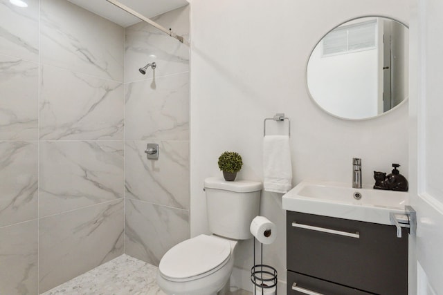 bathroom featuring vanity, toilet, and tiled shower