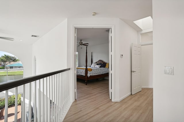 hallway featuring a skylight and light wood-type flooring