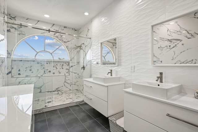 bathroom with walk in shower, vanity, tile walls, and tile patterned floors