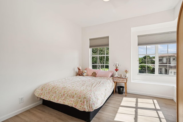 bedroom featuring light hardwood / wood-style flooring and multiple windows