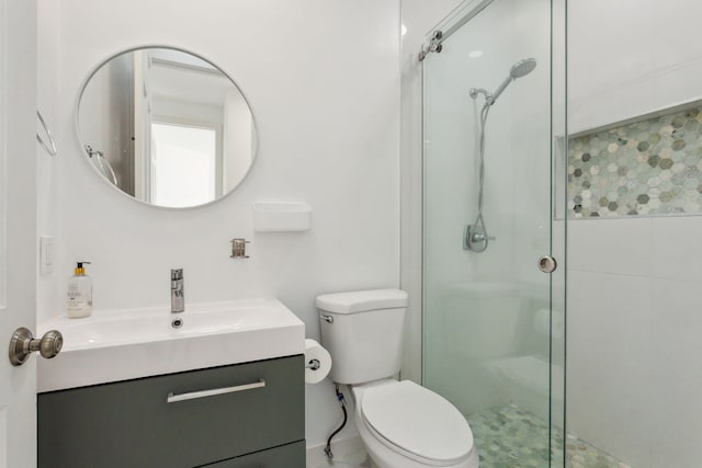 bathroom featuring an enclosed shower, vanity, and toilet