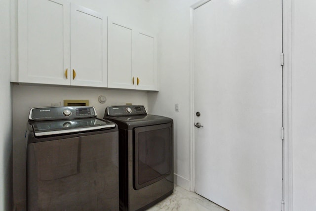 laundry area featuring washer and clothes dryer and cabinets