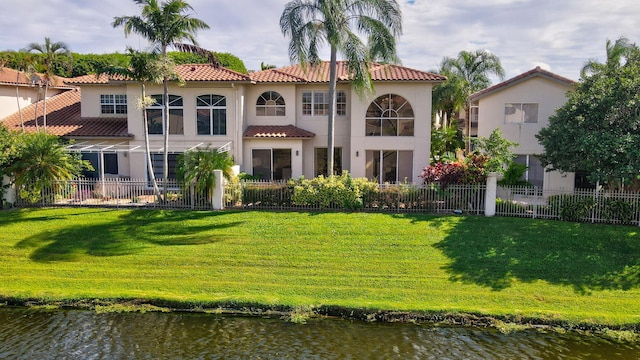 back of property featuring a lawn and a water view