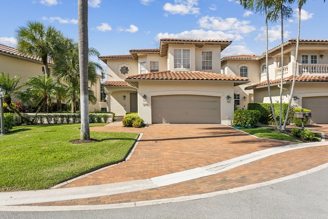 mediterranean / spanish home with a garage and a front lawn