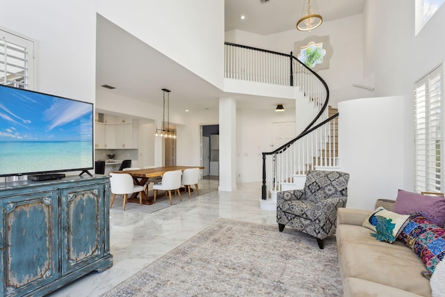 living room featuring a towering ceiling and a chandelier