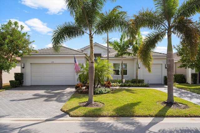 ranch-style house featuring a garage and a front lawn