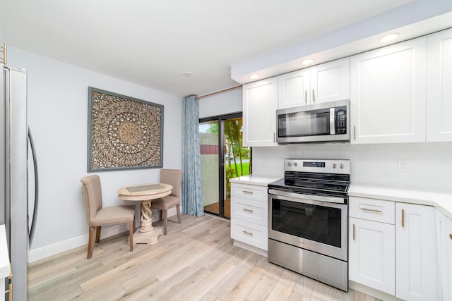 kitchen with white cabinetry, light hardwood / wood-style floors, appliances with stainless steel finishes, and tasteful backsplash