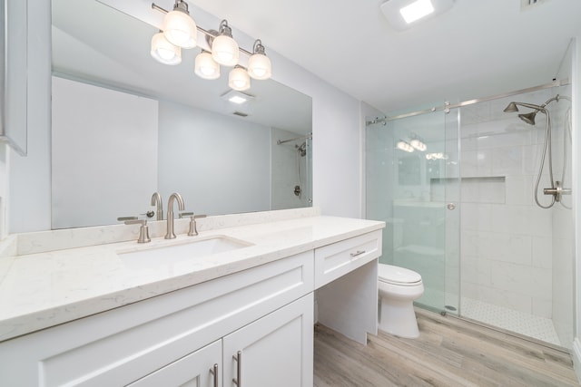 bathroom with hardwood / wood-style floors, vanity, toilet, and an enclosed shower