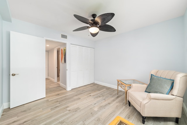 living area featuring light hardwood / wood-style floors and ceiling fan