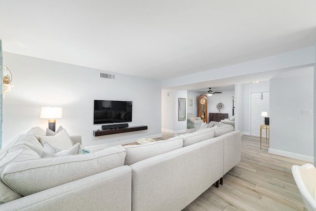 living room with light hardwood / wood-style floors and ceiling fan