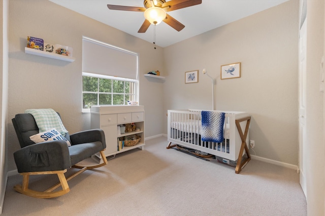 bedroom featuring a crib, carpet flooring, and ceiling fan