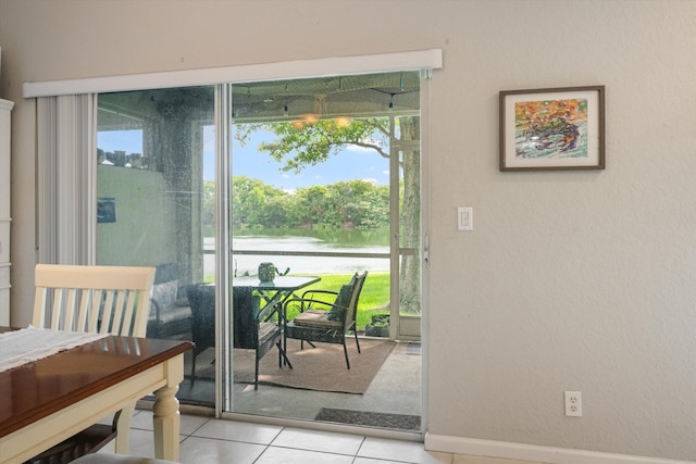 doorway featuring a water view and light tile patterned flooring