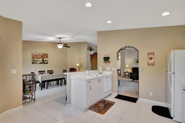 kitchen featuring white cabinetry, white appliances, kitchen peninsula, ceiling fan, and sink