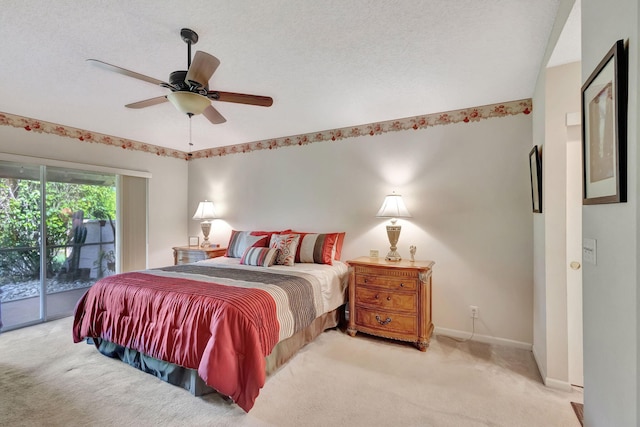 carpeted bedroom featuring ceiling fan, access to exterior, and a textured ceiling