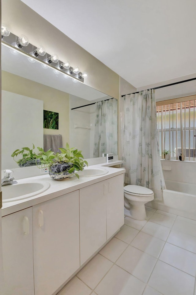 full bathroom with shower / tub combo with curtain, tile patterned floors, vanity, and toilet