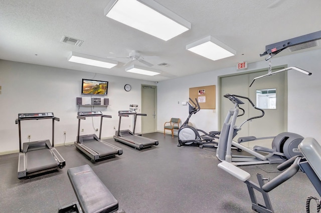 gym with ceiling fan and a textured ceiling