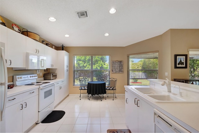 kitchen with plenty of natural light, white appliances, white cabinetry, and sink