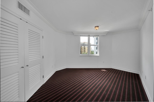 unfurnished bedroom with a closet, ornamental molding, and carpet