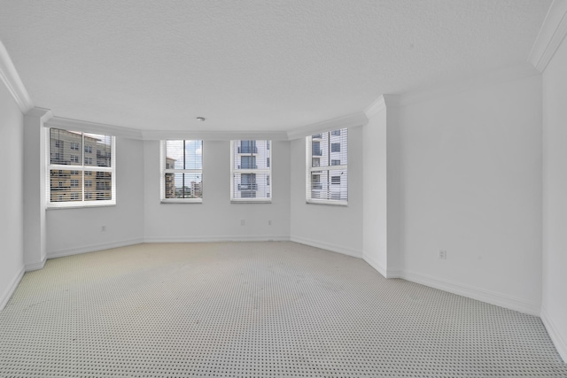 unfurnished room with ornamental molding, a textured ceiling, and light carpet