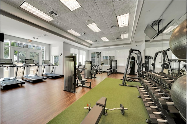 gym with hardwood / wood-style floors and a paneled ceiling