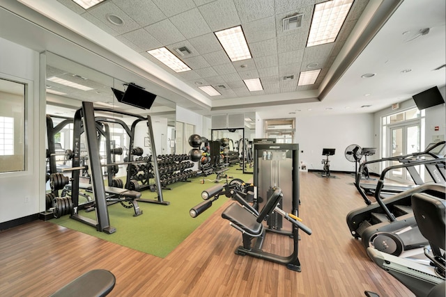 gym featuring wood-type flooring and a drop ceiling