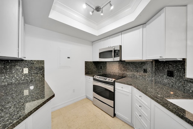 kitchen featuring dark stone countertops, white cabinets, stainless steel appliances, and tasteful backsplash