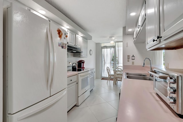 kitchen featuring light tile patterned flooring, white cabinets, white appliances, ceiling fan, and sink