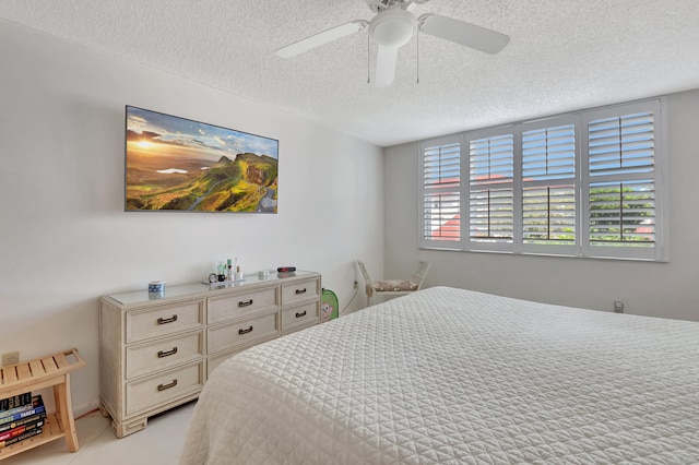 bedroom featuring ceiling fan, light colored carpet, and a textured ceiling