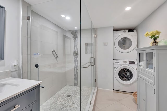 bathroom with stacked washer / drying machine, vanity, walk in shower, and tile patterned floors