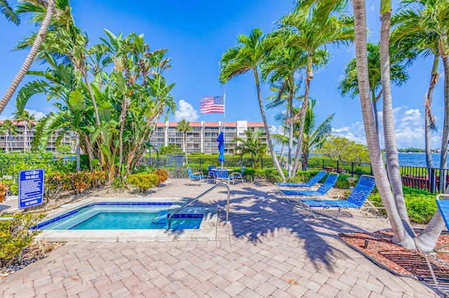 view of pool featuring a water view and a patio