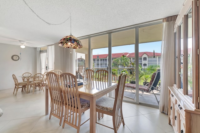 tiled dining room with ceiling fan and a textured ceiling