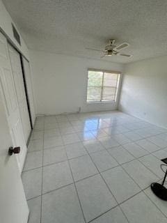 tiled spare room featuring ceiling fan