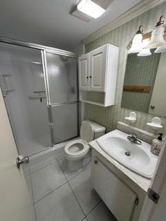 bathroom with walk in shower, tile patterned floors, ornamental molding, vanity, and toilet