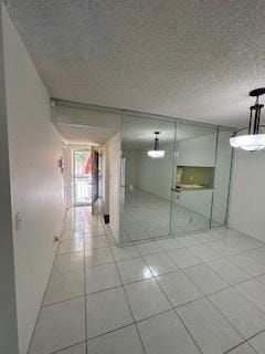 interior space with a textured ceiling and light tile patterned floors