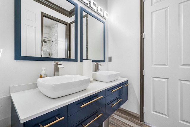 bathroom with walk in shower, vanity, and wood-type flooring