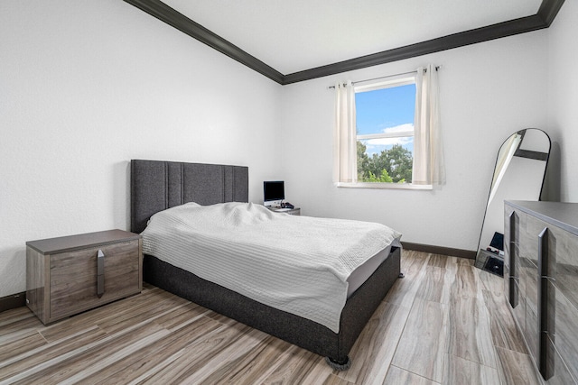 bedroom with ornamental molding and light wood-type flooring