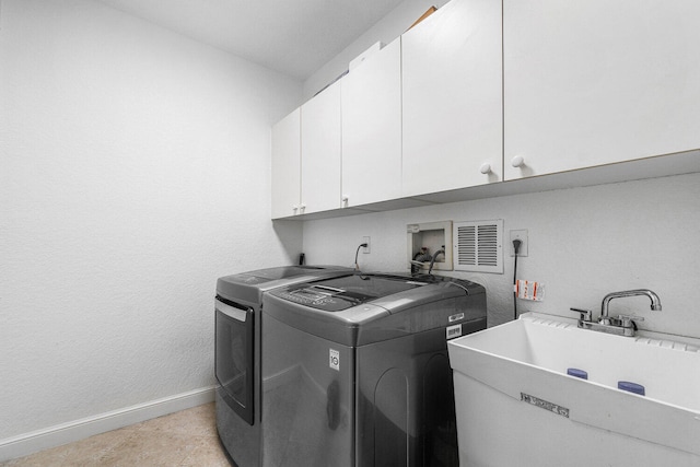 laundry area featuring washer and clothes dryer, cabinets, and sink