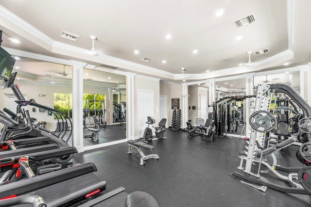 exercise room featuring ornate columns, crown molding, and a tray ceiling