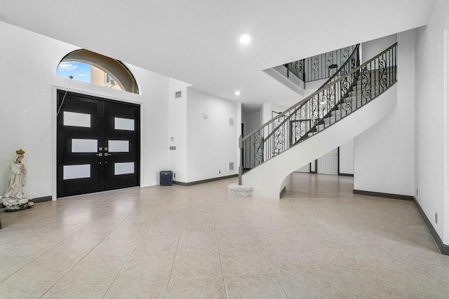 entrance foyer with light tile patterned flooring and french doors