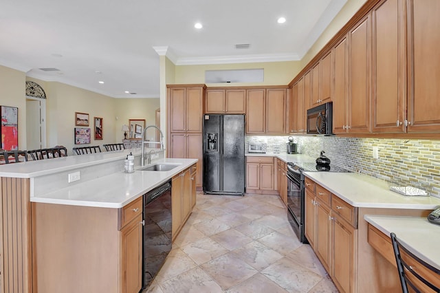 kitchen with a kitchen breakfast bar, black appliances, crown molding, a center island with sink, and sink