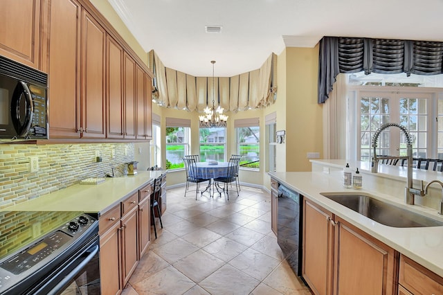 kitchen with pendant lighting, sink, a notable chandelier, decorative backsplash, and black appliances